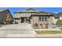 Charming two-story home with stone accents, landscaped yard, and inviting front porch at 8259 Arapahoe Peak St, Littleton, CO 80125