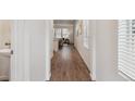 Bright hallway with hardwood floors leading to an open living area and a convenient powder room at 645 Flintwood Pl, Lafayette, CO 80026