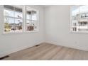 A clean, empty room with wood floors and bright natural light coming through large windows at 8386 Cokedale Cir, Littleton, CO 80125