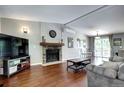 Cozy living room boasts a stone fireplace, hardwood floors, and an open layout at 4833 S Pitkin Ct, Aurora, CO 80015