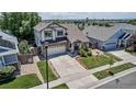 Aerial view of a two-story home with a well-manicured lawn, long drive, and inviting front porch at 16352 E 104Th Way, Commerce City, CO 80022