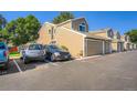 Exterior view of townhouse complex with garage and multiple cars parked in open spaces at 7476 E Arkansas Ave # 35-10, Denver, CO 80231