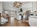Open-concept kitchen with stainless steel appliances, a granite countertop, and hardwood floors at 19820 E Amherst Dr, Aurora, CO 80013