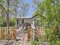 Inviting home exterior featuring a picket fence, stone walkway, and verdant landscaping at 6047 S Hill St, Littleton, CO 80120