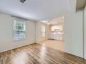 Sunlit living room features hardwood floors, flowing into the kitchen with white appliances at 6047 S Hill St, Littleton, CO 80120