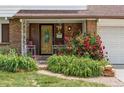 Inviting front porch with brick accents, vibrant roses, and a decorative wood and glass door at 9290 Quitman St, Westminster, CO 80031
