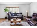 Cozy living room with plush leather sofas, wood floors, and a sunlit window at 9290 Quitman St, Westminster, CO 80031
