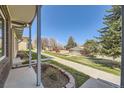 View from covered porch overlooking the grassy lawn and playground, showcasing the community amenities at 610 S Xenon Ct, Lakewood, CO 80228