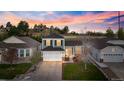 Beautiful home with a spacious driveway, lush green lawn, and a backdrop of mature trees at sunset at 11825 Meadowood Ln, Parker, CO 80138