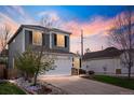 Two-story home with a white two-car garage, complemented by a well-maintained lawn and inviting driveway at 11825 Meadowood Ln, Parker, CO 80138