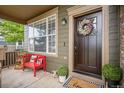 Cozy front porch with a red bench and decorative wreath on the front door at 11681 Night Heron Dr, Parker, CO 80134