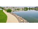 Scenic view of pond with a paved path surrounded by lush greenery and landscaping at 15555 E 40Th Ave # 30, Denver, CO 80239