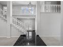Grand foyer with a staircase, chandelier, balcony, and dark tile entryway, leading to the home's interior at 4505 S Yosemite St # 125, Denver, CO 80237