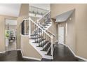 Elegant hallway with a staircase featuring dark wood steps and an iron and wood railing at 8410 S Oak St, Littleton, CO 80127