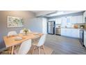 Dining room with stainless steel appliances, a skylight, white cabinets, and laminate flooring at 5250 S Huron Way # 11-206, Littleton, CO 80120