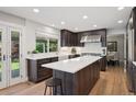 Bright, modern kitchen with white countertops, dark cabinetry, stainless steel appliances, and a large island at 2187 Wynterbrook Dr, Highlands Ranch, CO 80126