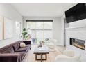 Bright living room features a sleek fireplace, large windows, and stylish, modern furniture at 2435 S High St, Denver, CO 80210