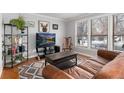 Bright living room featuring a leather sofa and large TV at 401 S Dover Ct, Lakewood, CO 80226