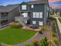A spacious backyard with a patio, outdoor seating, a lush lawn, and thoughtful landscaping at 12940 Brier Ct, Firestone, CO 80504
