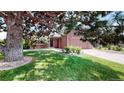 Charming home featuring mature landscaping, lush grass, and a welcoming entry at 4396 Dearborn St, Denver, CO 80239