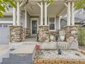 Stone pillars and a covered porch with a gray door at 10468 Wagon Box Cir, Highlands Ranch, CO 80130