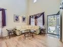 Light and airy living room with hardwood floors and a large sectional sofa at 10468 Wagon Box Cir, Highlands Ranch, CO 80130