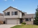 Charming two-story home featuring an attached two-car garage, manicured lawn, and brick accents at 5204 S Parfet Way, Littleton, CO 80127