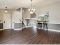 Bright and airy living room featuring hardwood floors, staircase and view into the kitchen at 5204 S Parfet Way, Littleton, CO 80127