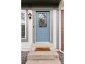 Close up of a blue front door with decorative glass and a brown door mat at 9632 W Cornell Pl, Lakewood, CO 80227