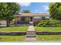 Charming brick home featuring a well-manicured lawn and inviting front porch at 1760 W 74Th Way, Denver, CO 80221