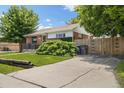 Charming brick home featuring a well-manicured lawn, driveway, and privacy fence at 1760 W 74Th Way, Denver, CO 80221