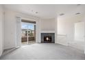 Inviting living room with a fireplace, balcony access and neutral carpet at 4100 Albion St # 617, Denver, CO 80216