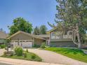 Attractive home exterior with well-manicured landscaping, a paved driveway, and green lawn at 5254 W Oberlin Dr, Denver, CO 80235