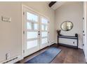 Bright foyer featuring a dark wood floor, a console table with a mirror, and a door with frosted glass panels at 5254 W Oberlin Dr, Denver, CO 80235