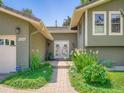 Inviting front entrance with beautiful landscaping and charming double doors at 5254 W Oberlin Dr, Denver, CO 80235