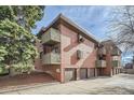 Exterior of condo building with brick and wood-style siding and private balconies above attached garages at 3050 W 32Nd Ave # 202C, Denver, CO 80211