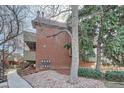 Exterior view of brick condominium building with landscaped grounds and building C marked on the side at 3050 W 32Nd Ave # 202C, Denver, CO 80211