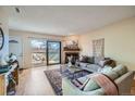 Cozy living room with fireplace, balcony access, and comfortable seating at 3050 W 32Nd Ave # 202C, Denver, CO 80211