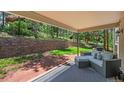 Covered patio featuring comfortable seating and views of the wooded backyard at 6100 Apache Dr, Larkspur, CO 80118