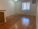 A spacious living room with hardwood floors, a white front door, and a bright window at 9300 E Florida Ave # 608, Denver, CO 80247