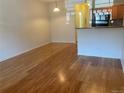 An open-concept living room leading to the kitchen, featuring hardwood floors and bright lighting at 9300 E Florida Ave # 608, Denver, CO 80247