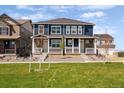 Inviting townhome with blue siding and stone accents, complemented by a well-maintained front yard at 9855 Biscay St, Commerce City, CO 80022