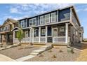 Beautiful townhome with blue siding, stone accents, and a charming front porch with white railings at 9855 Biscay St, Commerce City, CO 80022