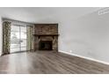 Living room with hardwood floors, stone fireplace and sliding glass door at 14191 E Jewell Ave # 203, Aurora, CO 80012