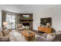 Virtually staged living room with stone fireplace and hardwood floors at 14191 E Jewell Ave # 203, Aurora, CO 80012