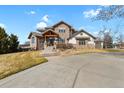 Stunning stone home featuring a grand entryway with a well manicured lawn at 2960 High Prairie Way, Broomfield, CO 80023