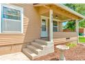 Inviting covered front porch with classic architectural details, providing a welcoming entrance to the home at 458 Cherry St, Hudson, CO 80642