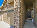 Close-up of the front door with stylish stone pillar and a peek at the garage and home's facade at 16658 Prospect Ln, Broomfield, CO 80023