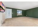 A cozy living room boasts neutral carpet and features a door and a window allowing natural light at 2916 S Jasper St, Aurora, CO 80013