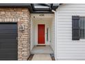 Close-up of a vibrant red front door framed by stone and light siding, offering curb appeal at 4391 Mcmurdo Ct, Castle Rock, CO 80108